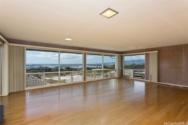 unfurnished living room featuring hardwood / wood-style floors and a textured ceiling