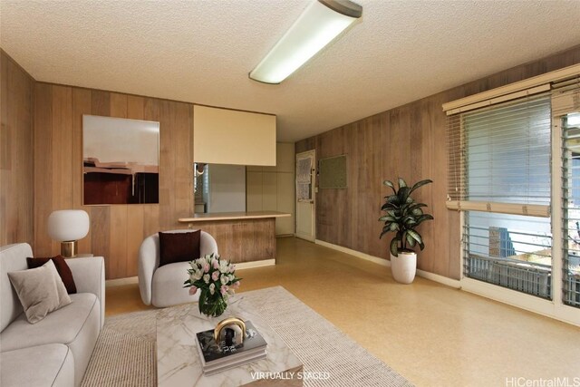 living room featuring a textured ceiling and wood walls