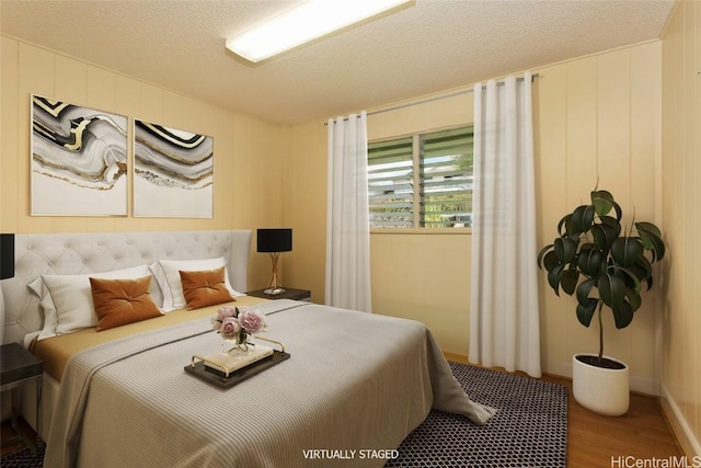 bedroom with wood-type flooring and a textured ceiling