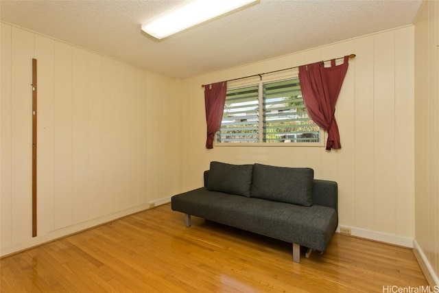 living area with a textured ceiling and light wood-type flooring