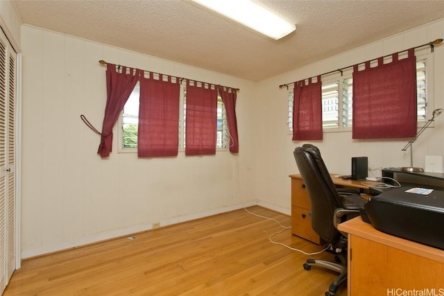 office area featuring wood-type flooring, a textured ceiling, and plenty of natural light