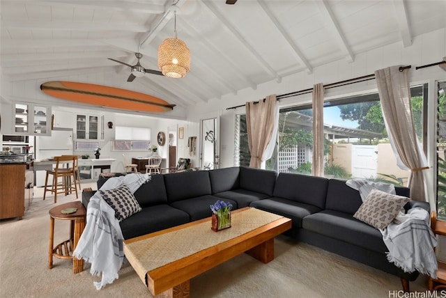 living area featuring ceiling fan and lofted ceiling with beams