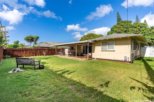 back of property with a patio area, a fenced backyard, and a yard