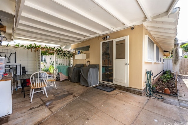 view of patio with outdoor dining area and fence