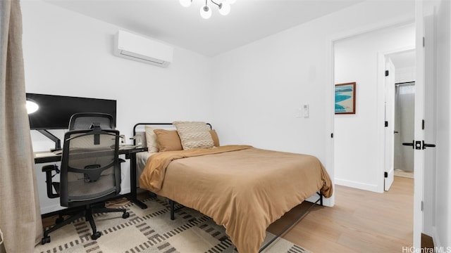 bedroom featuring a wall unit AC and light hardwood / wood-style flooring