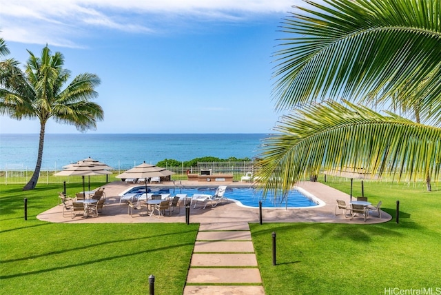 view of swimming pool featuring a water view, a yard, and a patio