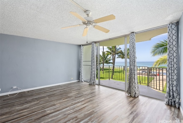 87-561 Farrington Hwy Unit 211, Waianae, HI 96792 - unfurnished room with expansive windows, a water view, wood finished floors, a ceiling fan, and a textured ceiling