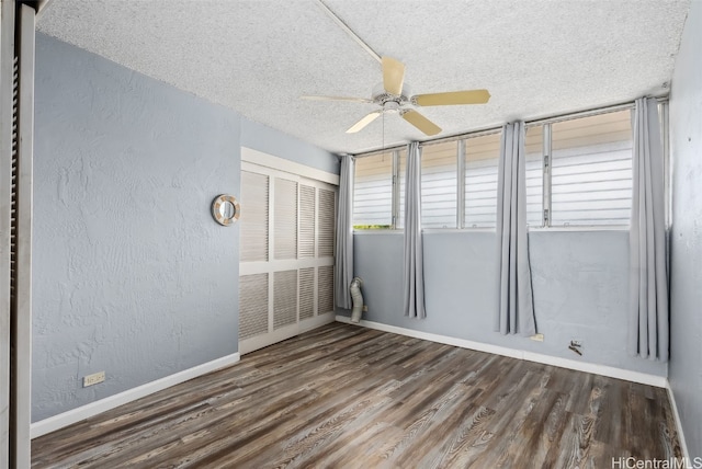 empty room featuring dark hardwood / wood-style flooring, ceiling fan, and a textured ceiling