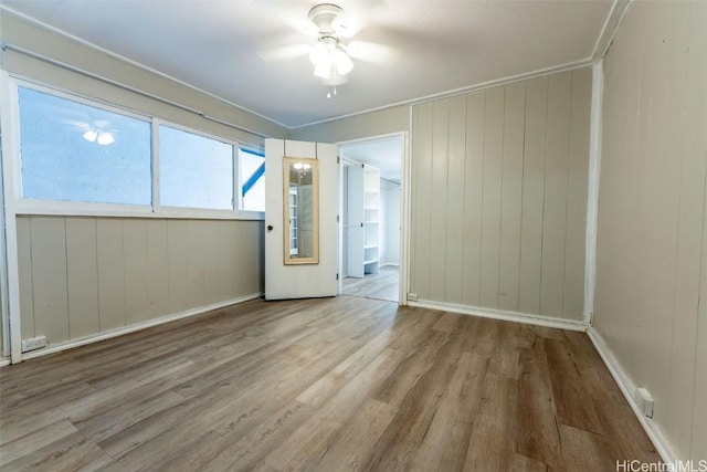 spare room featuring baseboards, ceiling fan, and wood finished floors