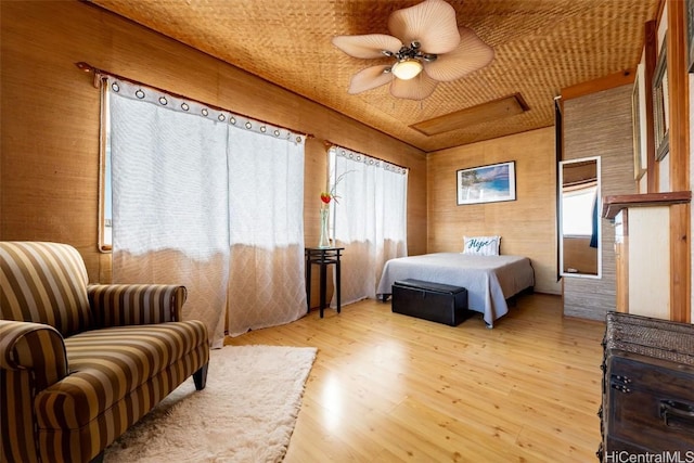 bedroom featuring ceiling fan, attic access, and light wood-style floors