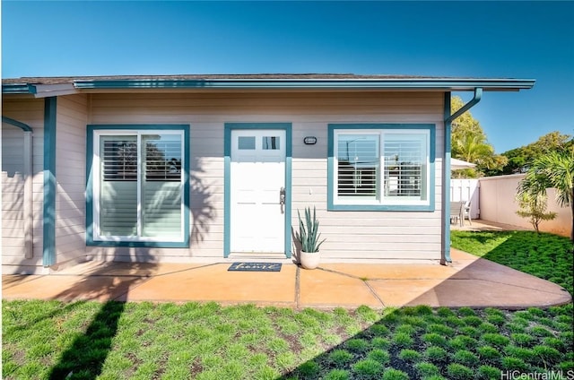 entrance to property with a yard and a patio