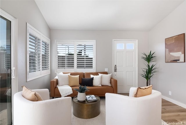 living room featuring vaulted ceiling and light hardwood / wood-style floors