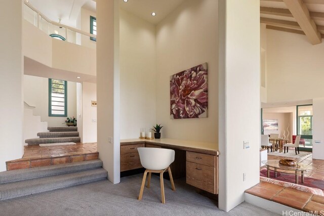 carpeted office featuring a towering ceiling