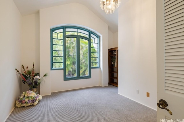 foyer entrance featuring vaulted ceiling, a chandelier, and carpet flooring