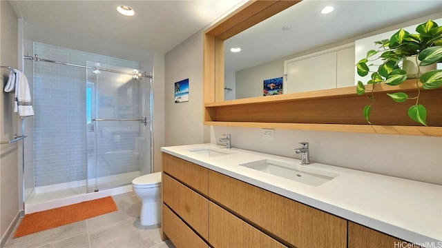 bathroom with a shower with door, vanity, tile patterned flooring, and toilet