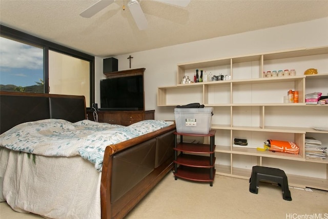 carpeted bedroom featuring ceiling fan and a textured ceiling