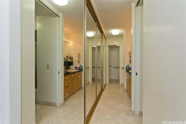 bathroom featuring vanity, an enclosed shower, and a textured ceiling