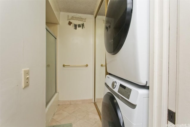 clothes washing area with light tile patterned floors, a textured ceiling, and stacked washer / dryer