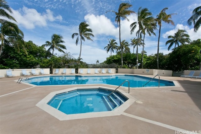 view of swimming pool with a hot tub and a patio