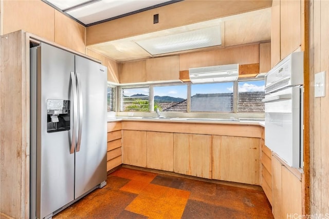 kitchen featuring light brown cabinetry, electric stovetop, sink, oven, and stainless steel fridge with ice dispenser