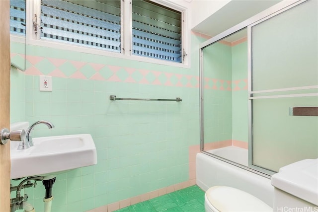 full bathroom featuring sink, toilet, and combined bath / shower with glass door