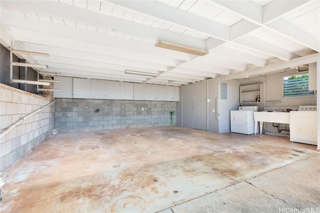 garage with electric panel, sink, and washing machine and dryer