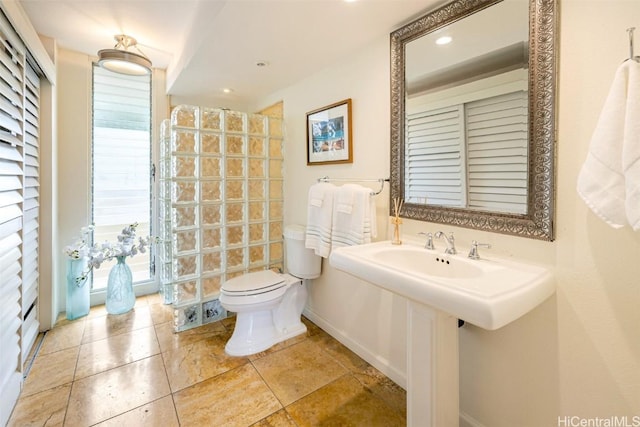 bathroom with baseboards, toilet, and walk in shower