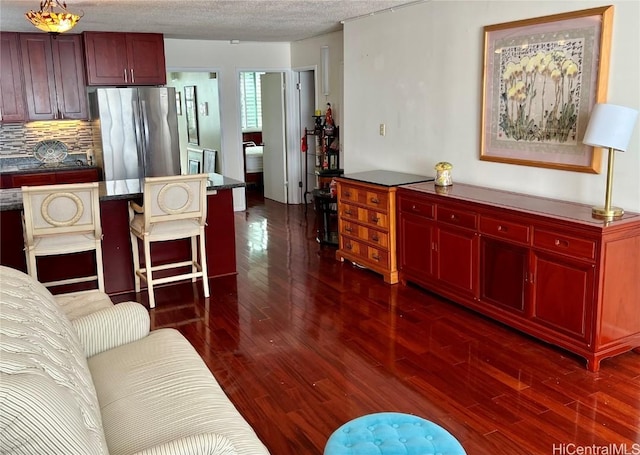 living room featuring a textured ceiling and dark hardwood / wood-style flooring