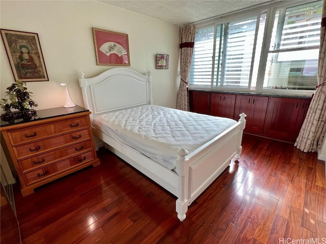 bedroom featuring dark hardwood / wood-style floors and a textured ceiling