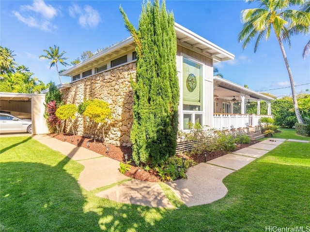 view of home's exterior with stone siding and a yard