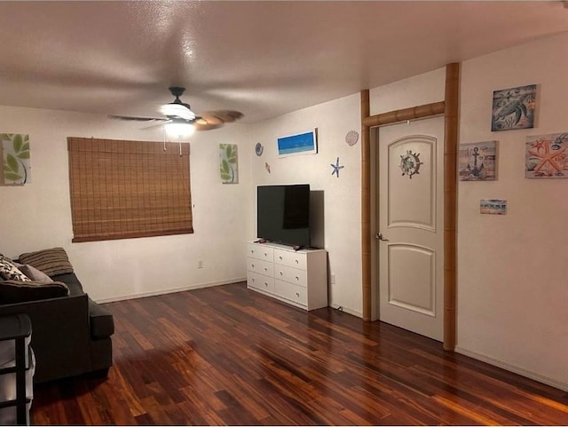 living room featuring dark wood-type flooring and ceiling fan