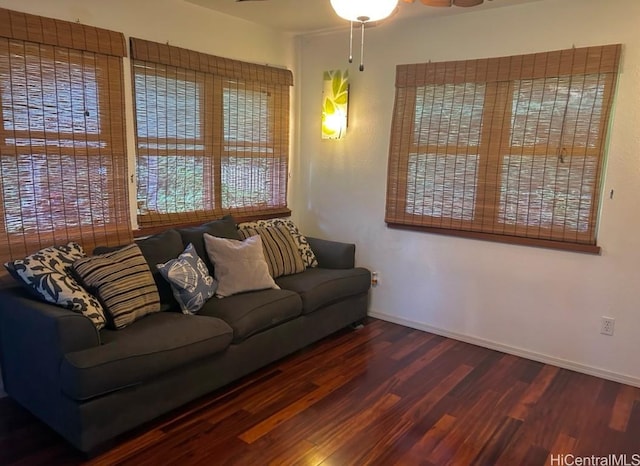 living room featuring dark wood-type flooring and ceiling fan