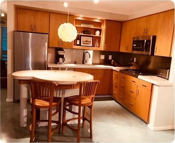 kitchen with brown cabinetry, light countertops, stainless steel appliances, and a sink