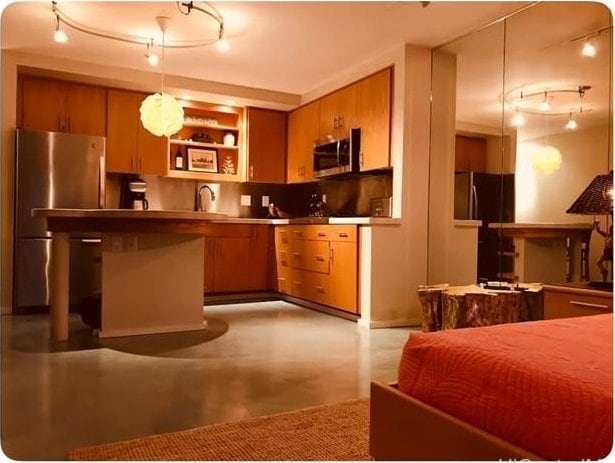 kitchen featuring appliances with stainless steel finishes, sink, kitchen peninsula, and decorative light fixtures