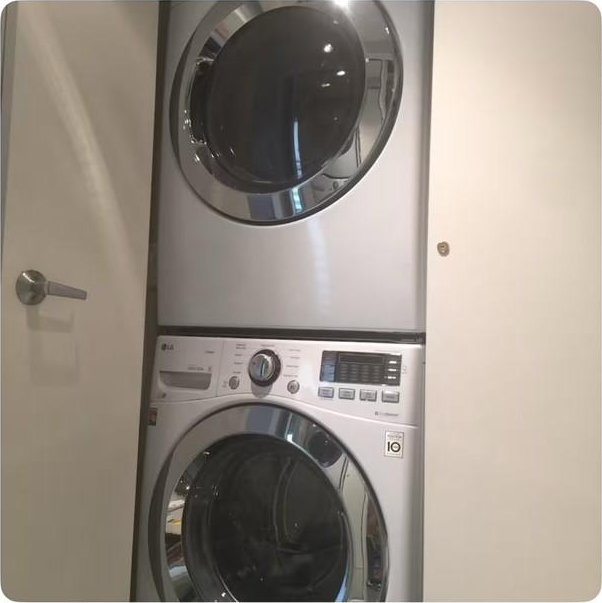 clothes washing area featuring stacked washer and dryer and a mail area