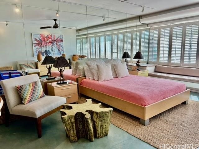 bedroom featuring finished concrete floors and rail lighting