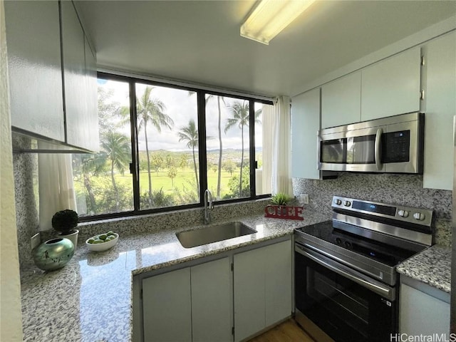 kitchen with a sink, tasteful backsplash, appliances with stainless steel finishes, and a healthy amount of sunlight