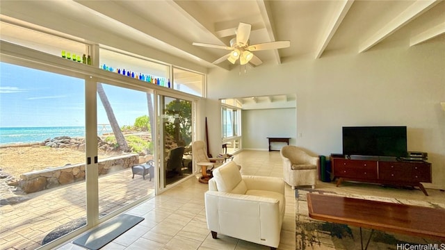 sunroom with beam ceiling, a water view, a beach view, and ceiling fan