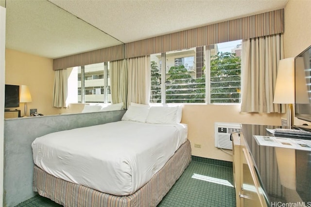 bedroom with a wall mounted AC, dark carpet, and a textured ceiling