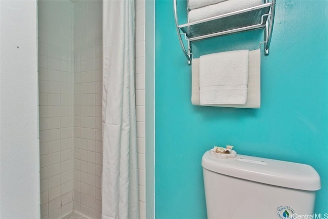 bathroom with toilet and a shower with shower curtain