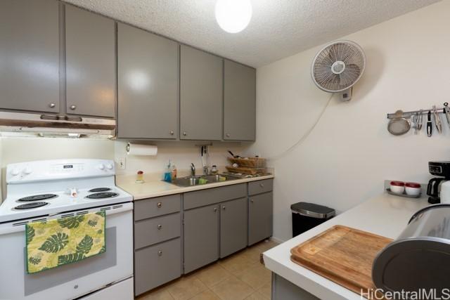 kitchen featuring gray cabinets, extractor fan, a textured ceiling, and white range with electric stovetop