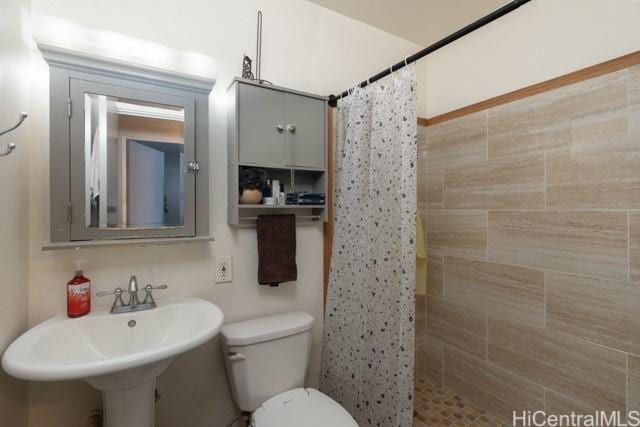 bathroom featuring sink, curtained shower, and toilet