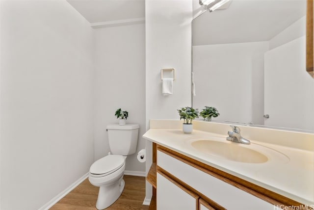 bathroom with vanity, toilet, and hardwood / wood-style floors