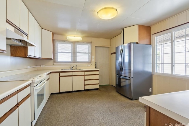 kitchen with white electric stove, under cabinet range hood, a sink, light countertops, and stainless steel fridge