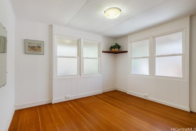 unfurnished room featuring baseboards and hardwood / wood-style flooring