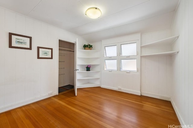 unfurnished bedroom with a closet, baseboards, and wood finished floors