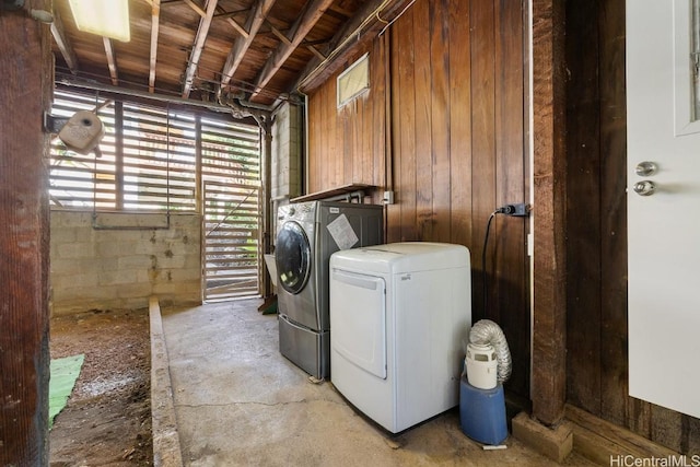 laundry area featuring washer and dryer, laundry area, and concrete block wall