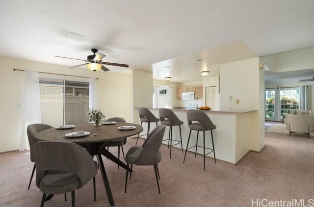 carpeted dining space featuring ceiling fan