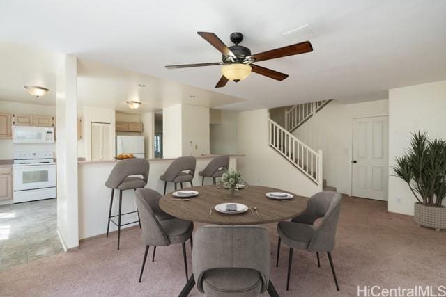 carpeted dining space featuring ceiling fan