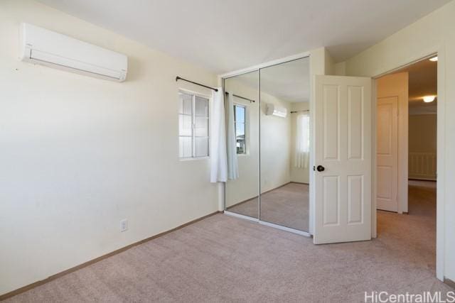 unfurnished bedroom with light colored carpet, a closet, and a wall mounted AC